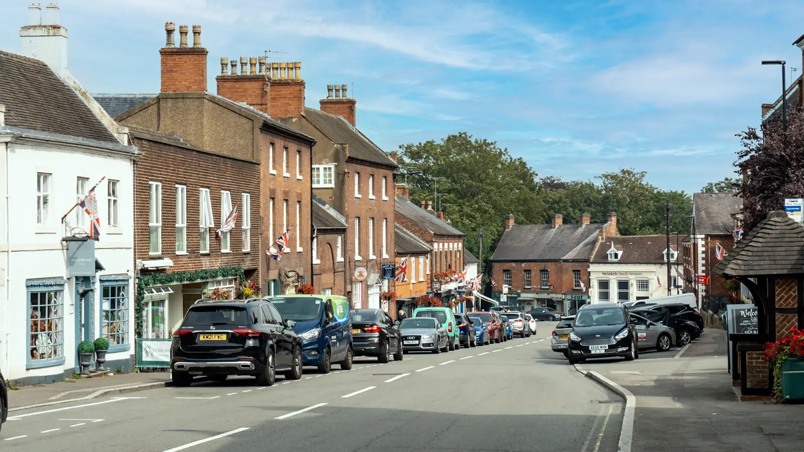 A street in Tutbury, lined with cars.